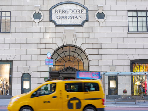 a yellow taxi cab drives by Bergdoof Goodman's on 5th ave, manhattan  skyline photographed Askao Imamura