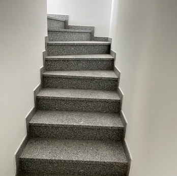 Neu verlegte Granittreppe mit gemustertem Steinbelag im Treppenhaus
