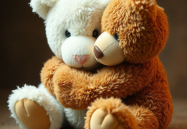 brown teddybear cuddling a white sad teddybear both are looking away from the camera