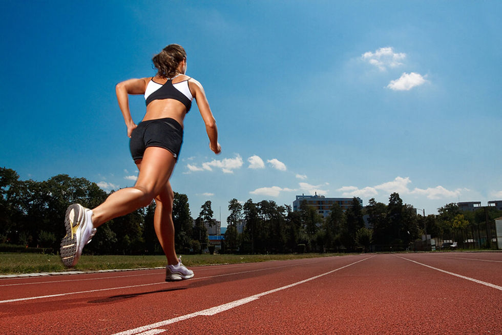 Chica corriendo en una pista de atletismo