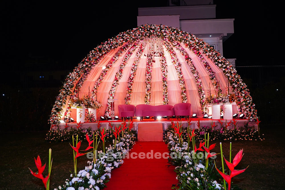 Floral dome stage with red carpet and pink seating