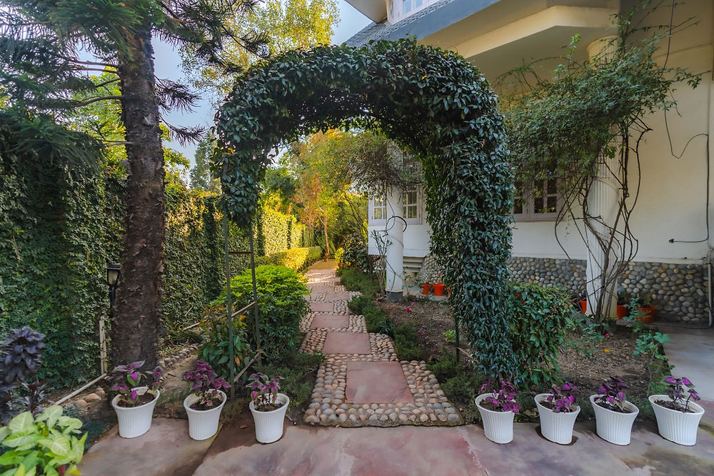 Lush garden path and archway at a luxury villa in Dehradun