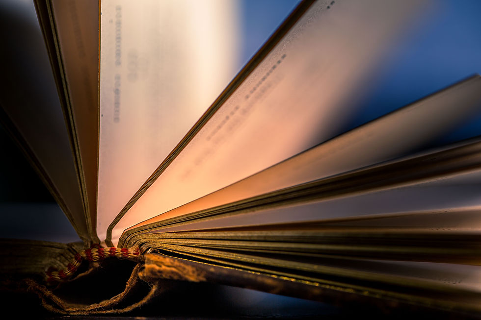 An open antique book, its pages lit in warm tones. This image evokes the mystery and wisdo