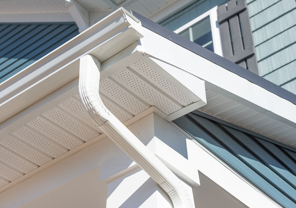 White gutter system on a house exterior with blue siding and shutters. 