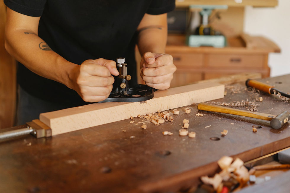 Hands using a hand plane on a wooden board; representative woodworking photograph.