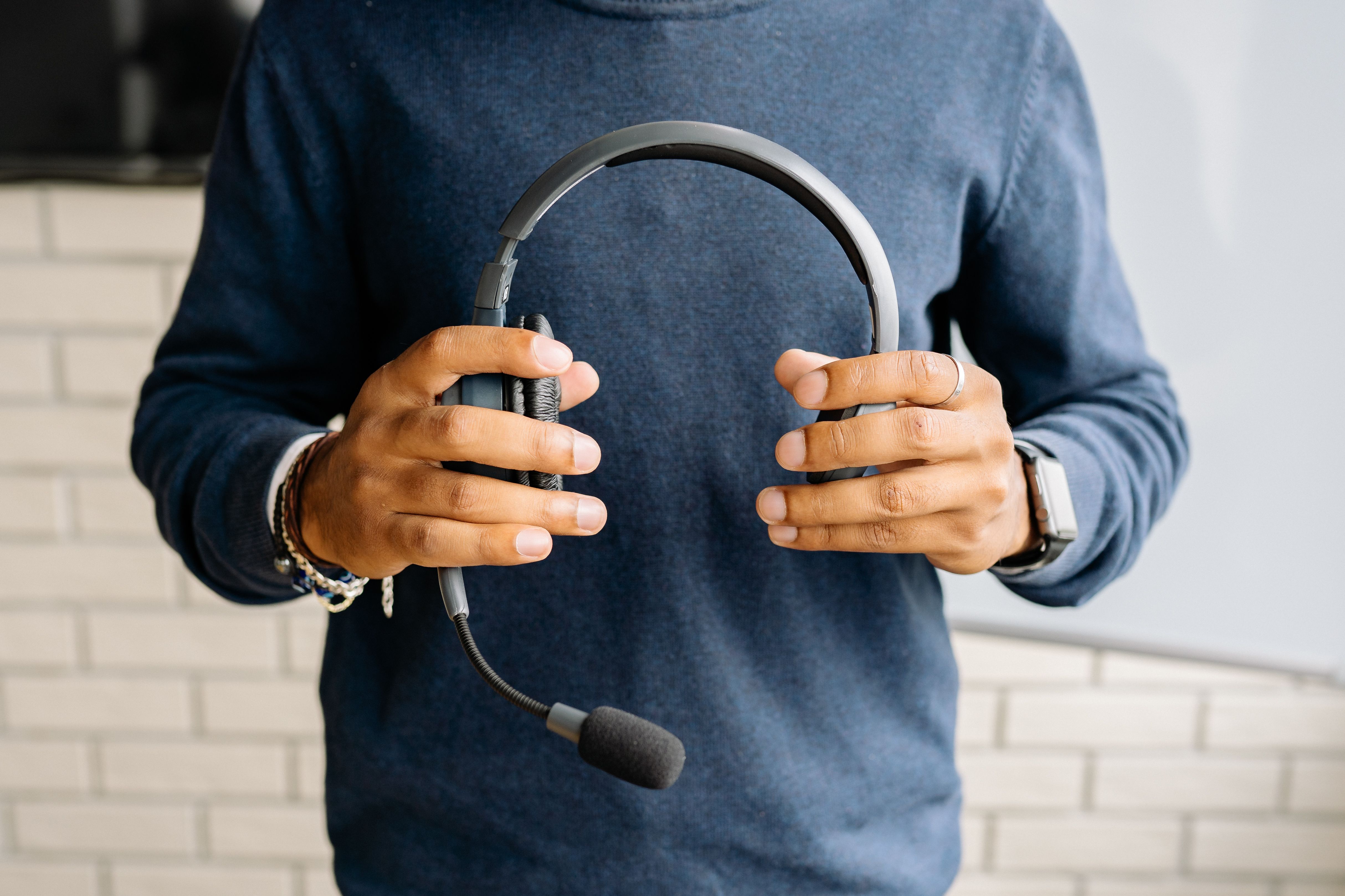 A person holding a headset with a boom microphone.