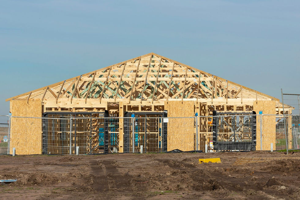 Wooden building under construction with exposed framing and roof trusses