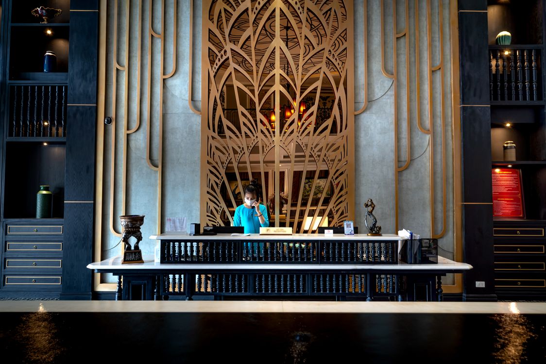 A person standing behind an ornate reception desk.
