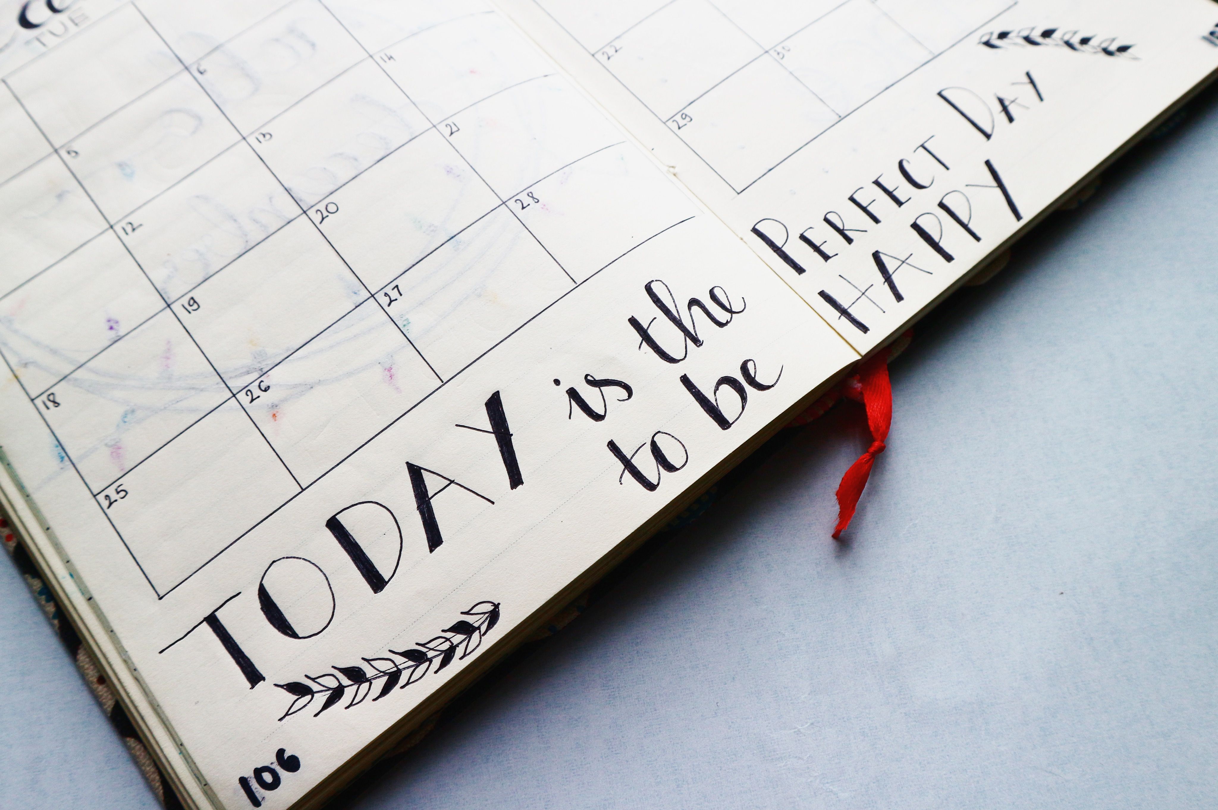 An open paper planner showing a calendar grid and handwritten notes.