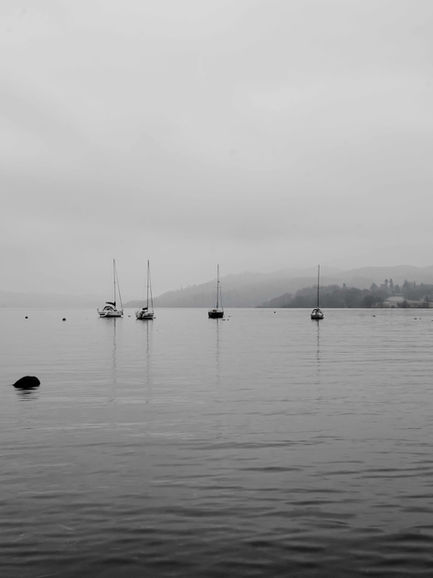 Moored Boats On A Serene Misty Waterscape. The Lake District, UK
