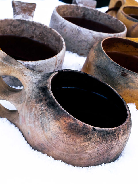 Hand-carved Kuksa cups sat embedded into snow.