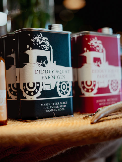 Image of Diddly Squat Farm Gins on display atop a hessian sack covered table.