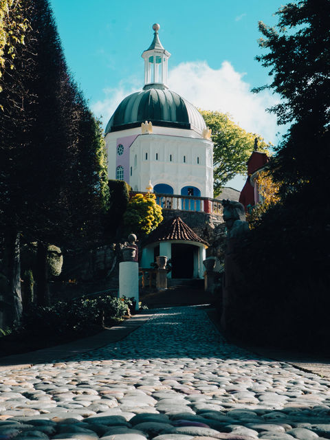 This image shows the Dome at Portmeirion from street level, focusing on the cobbled street with the Dome towering in the background of the image.