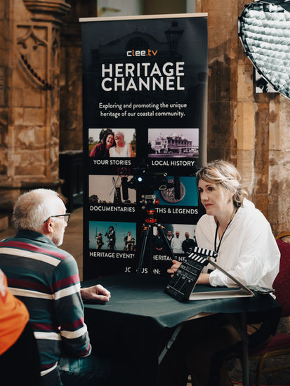 The image shows a man being interviewed by a woman with the backdrop of the Clee.TV Heritage Channel banner.
