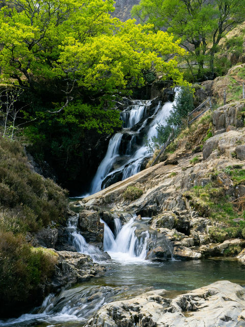 The glowing greens of Spring in Wales emerge around the tranquil falls of Cwm Llan, making their way down from the heights of Snowdon and running parallel to the Watkin Path.