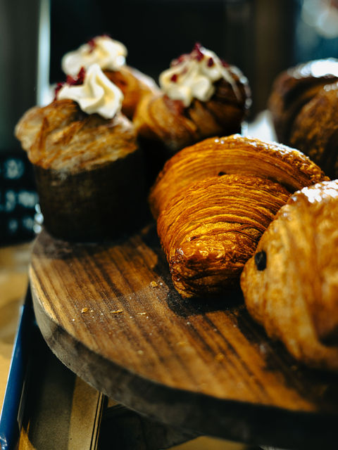 The images shows various pastries displayed including croissants, cupcakes and pain au chocolates.