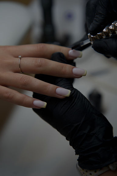 Nail technician applying polish during a manicure class.