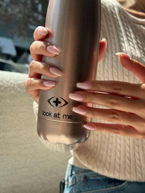 Woman holding a Look At Me water bottle.
