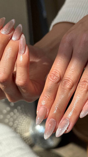 Long almond-shaped manicured nails with shimmering polish