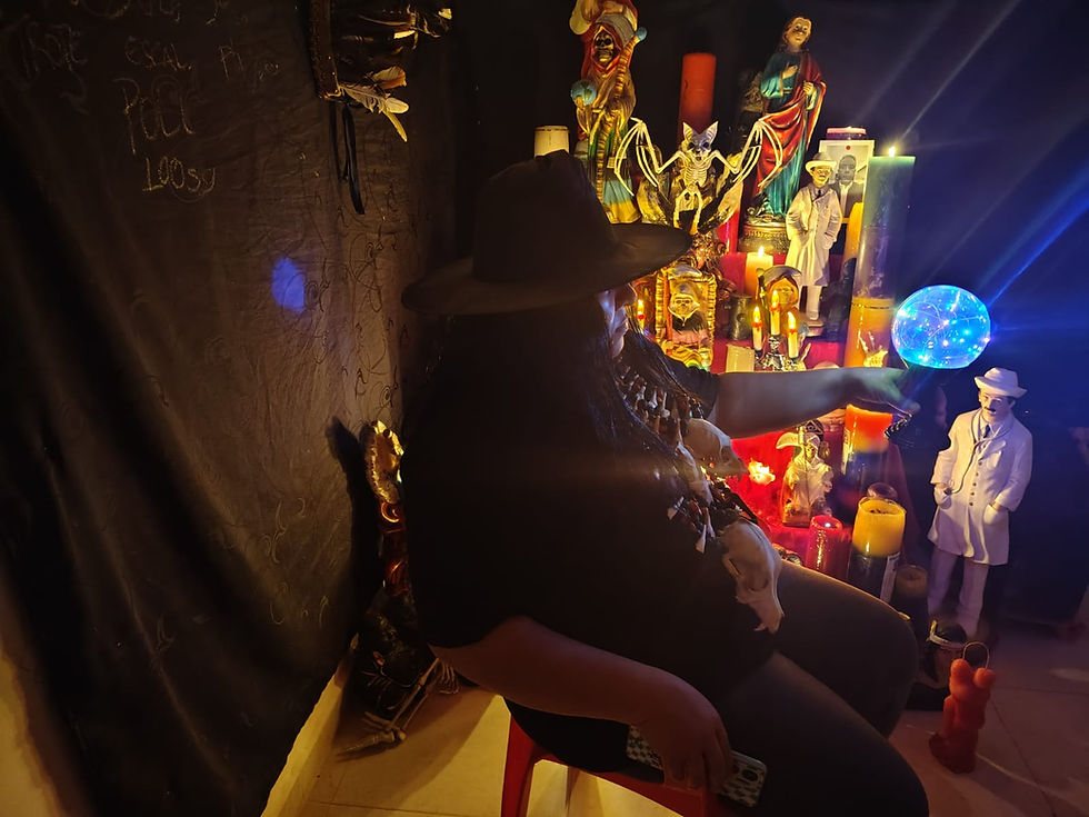 Maestra Victoria con esfera luminosa realizando ritual espiritual frente a altar con velas e imágenes místicas.