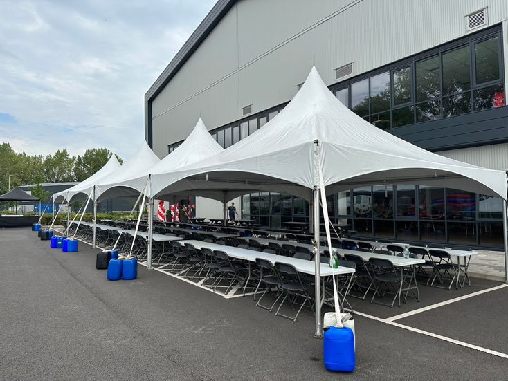 6x24meters marquee setup in the car park for a business event. This also includes tables, chairs and bouncy castles.