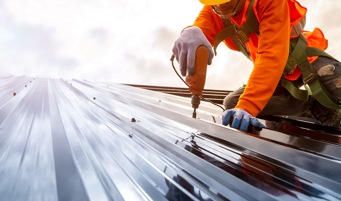 A Construction Worker Installs a Metal Roof Using Power Tools - Daniel Builders