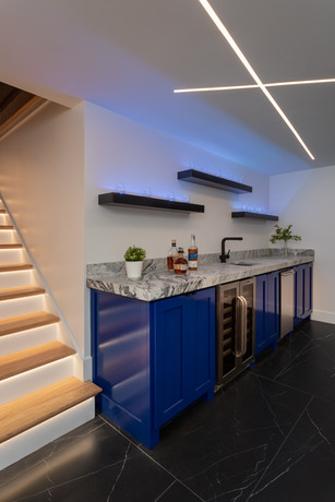 Chanticleer Home After Basement Area Converted to Wine Room With Floating Shelves Above Bar Area - Daniel Builders