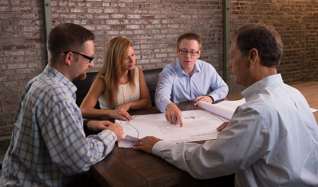 Client Meeting with Daniel Builders Team in the Boardroom Reviewing Home Plans - Daniel Builders