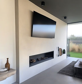 Seamless exterior resin-based MicroCement fireplace wall with mounted TV and modern linear fireplace in West Vancouver