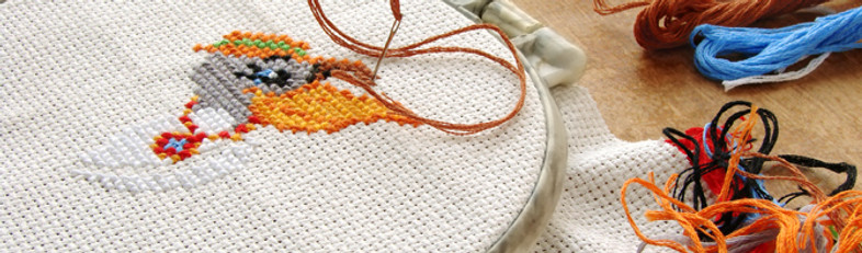 Cross stitch supplies including a hoop, floss threads and scissors