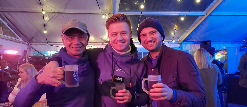 3 mannen lachend en poserend met een glas bier op een kerstmarkt in Winterberg