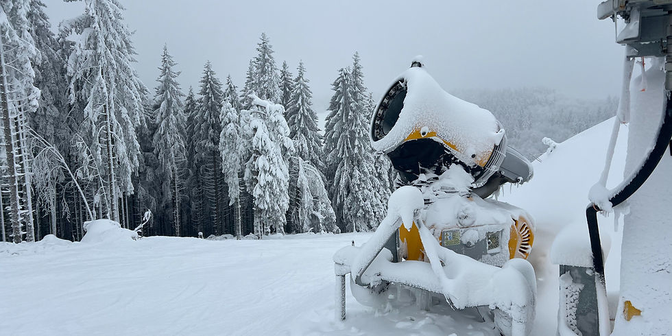 Sneeuwkanon in Winterberg Duitsland, flink onder de sneeuw met op de achtergrond een besneeuwde ski piste en besneeuwde bomen.