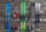 verschillende skispullen die klaarliggen om ingepakt te worden zoals ski's, skischoenen, skistokken, sneeuwschep.