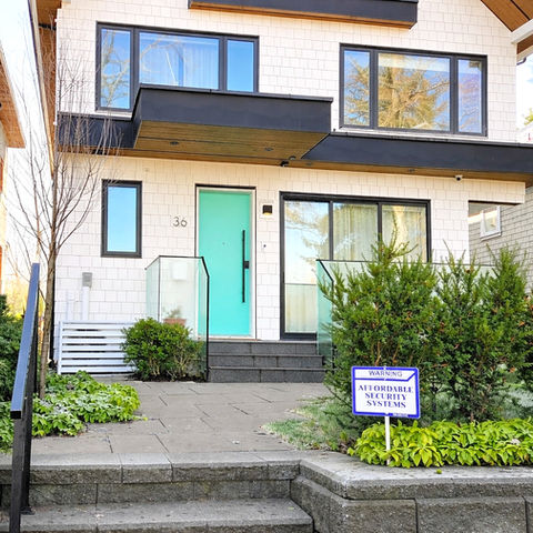 Front unit entrance with a short walkway, landscaped planting, and a recessed door beneath an upper level overhang.