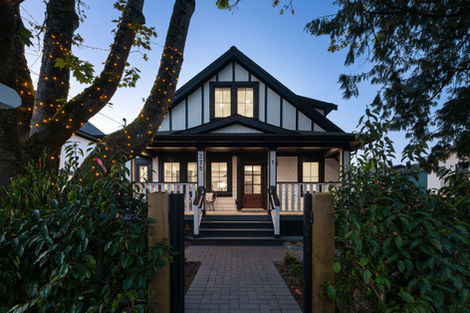 Night view of the 375 character retention duplex with porch lighting and illuminated windows under the gable roof form.