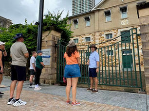 A tour guide standing in front of the Commissariat Store in Brisbane.