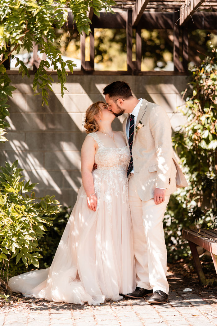 Bride and groom share an intimate moment at the Dunedin botanic gardens, shot by photographer Nakita Marx.