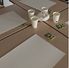 Vellen papier op tafel, bekertjes water en theezakjes