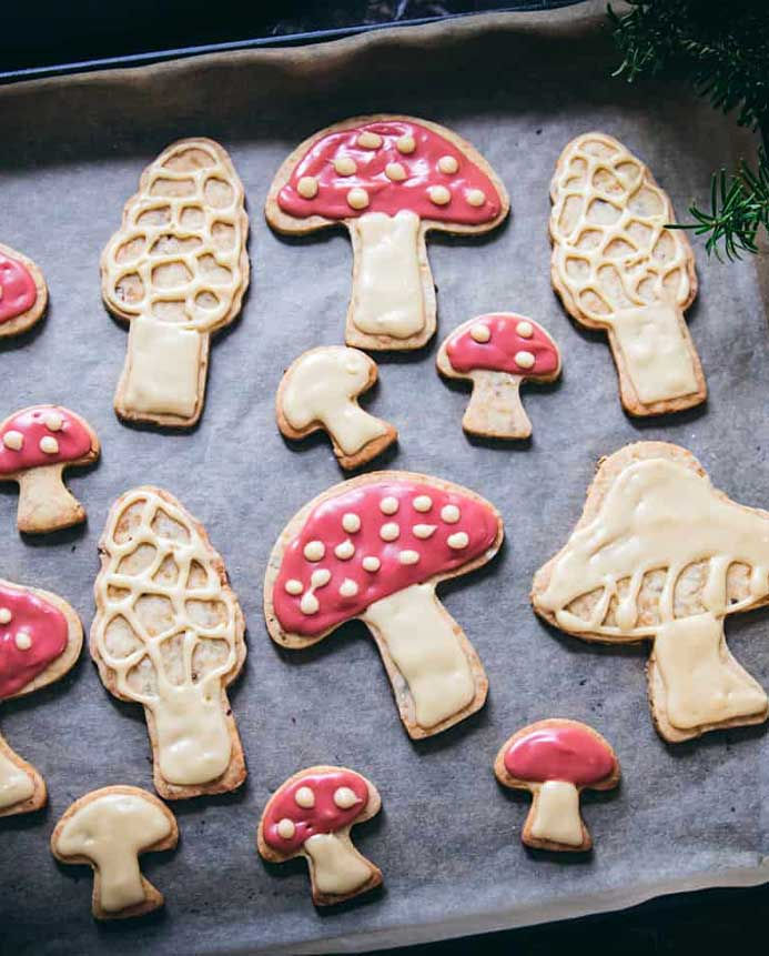 A baking sheet with mushroom shaped sugar cookies on top