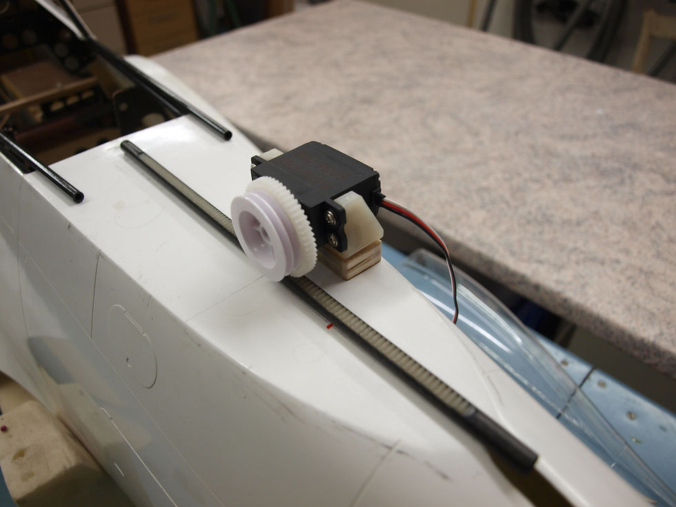 Bild zeigt die Zahnstange mit dem Servo, der dort eingreift und die Haube hin und her bewegt