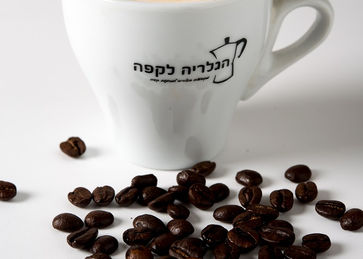 כוס קפה מעוצבת לצד פולי קפה