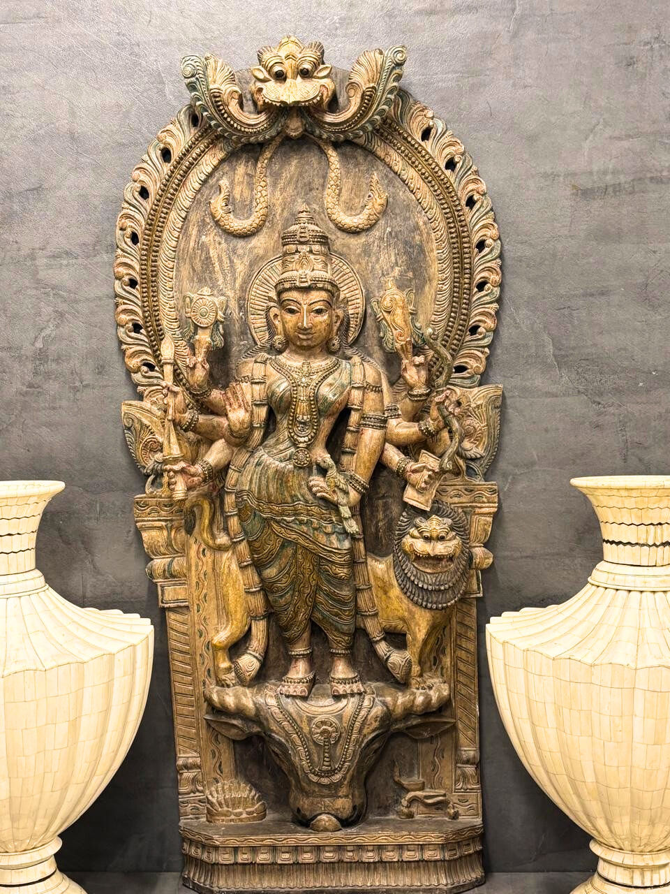 Handcarved wooden panel of Durga slaying Mahishasura. Divine wall decor with antique finish.