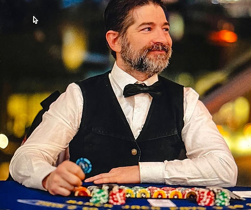 Professional blackjack dealer holding casino chips at a blackjack table.