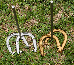 Horseshoe game rental in Ottawa – Two pegs with gold and silver horseshoes wrapped around them for outdoor fun at events and parties."