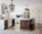 A large, bright kitchen with wooden accents and modern appliances and tile work.
