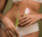 woman in bikini bottoms holds tulip