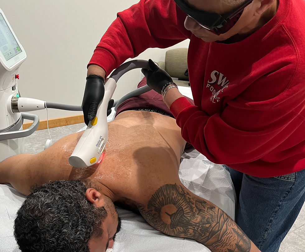 Grace performing laser hair removal on a man's back