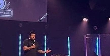 Andres Villalba speaking on stage at New Life Church