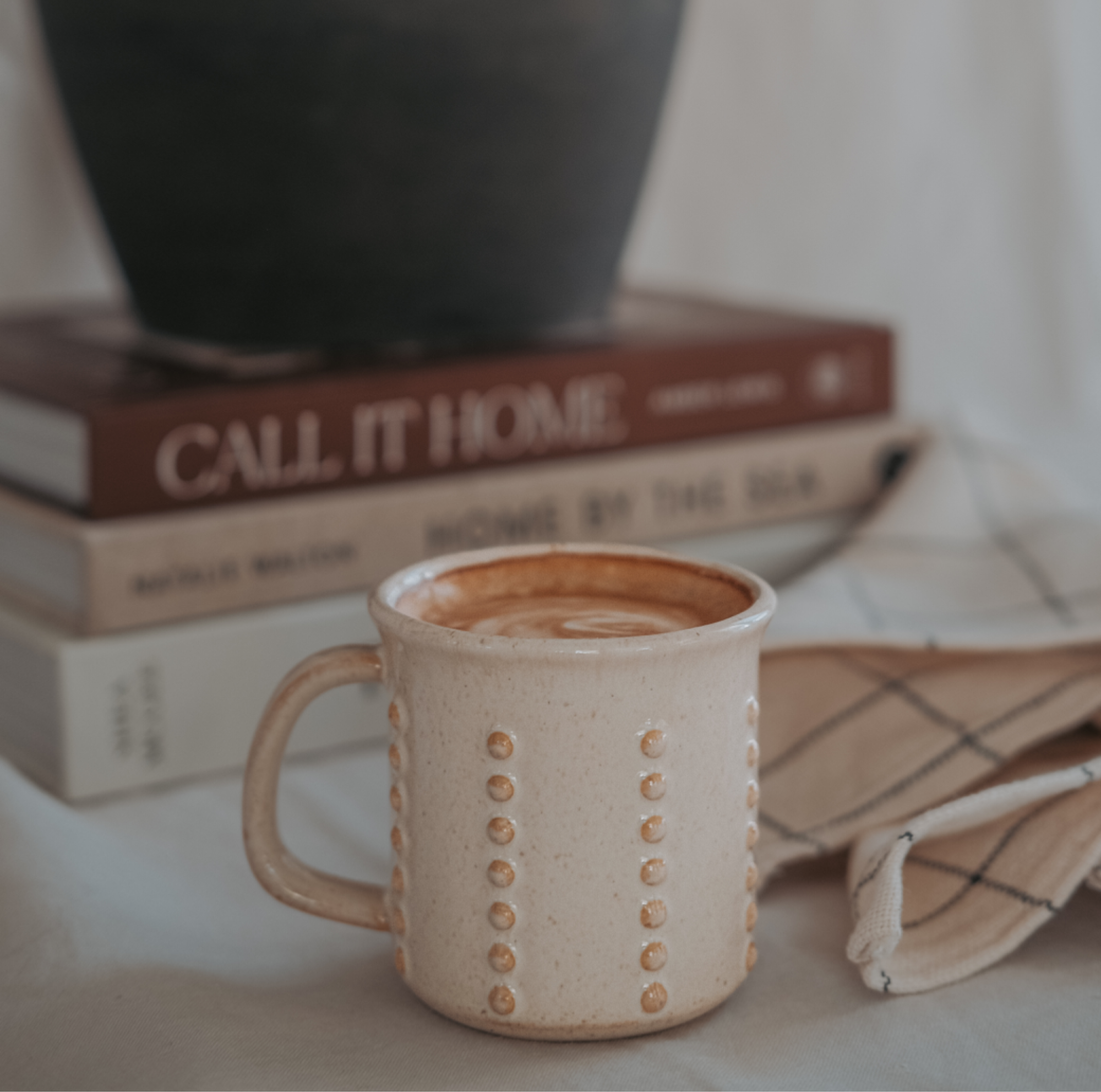 Tasse à expresso sur une table avec livre et vase noir