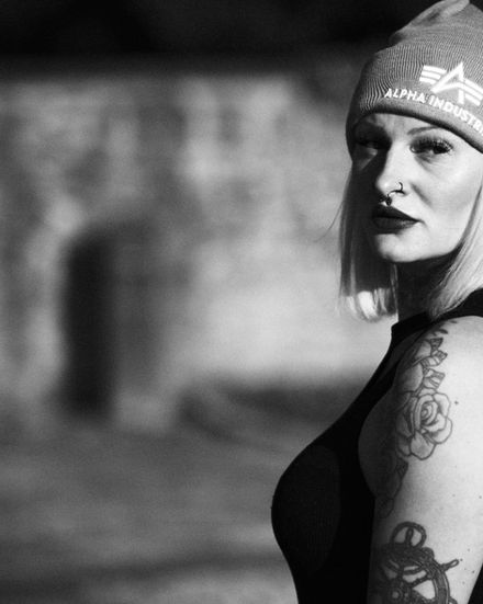 Intime Nahaufnahme von Natalie: Blick über die Schulter direkt in die Kamera, weicher Hintergrund durch Offenblende, in Schwarz-Weiß.